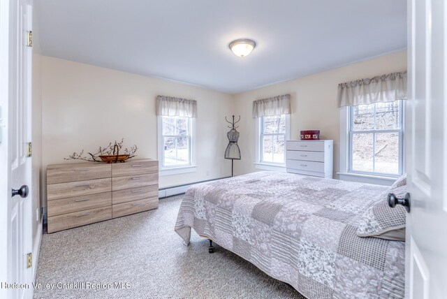 bedroom with baseboard heating and carpet flooring