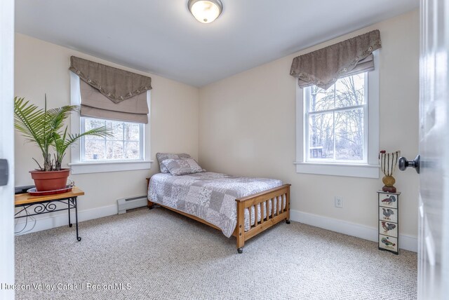 bedroom featuring a baseboard heating unit, carpet flooring, and baseboards