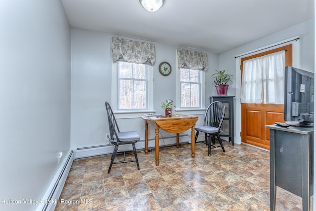 sitting room with stone finish floor, baseboards, and a baseboard heating unit