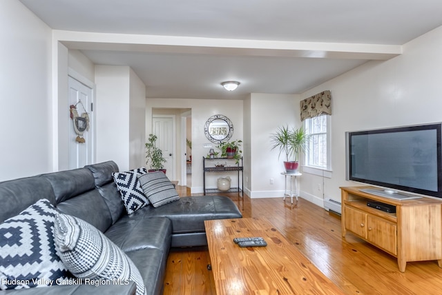 living room with a baseboard heating unit, light wood-style flooring, and baseboards