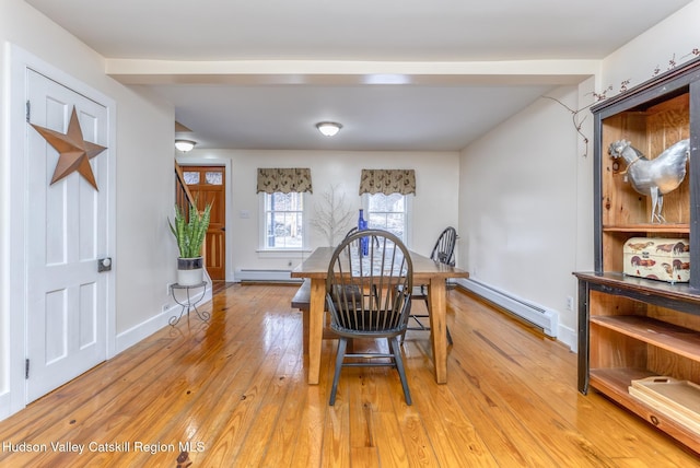 dining room featuring a baseboard heating unit, light wood-type flooring, a baseboard radiator, and baseboards