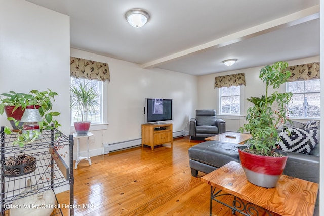 living area with light wood finished floors, baseboards, a baseboard heating unit, and beamed ceiling