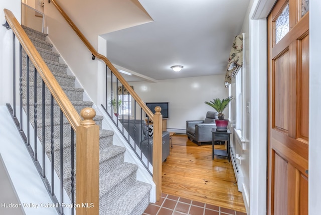 entryway featuring stairs, a baseboard radiator, and wood finished floors