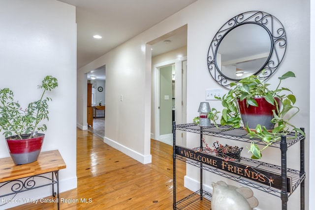 hallway featuring baseboards and light wood finished floors