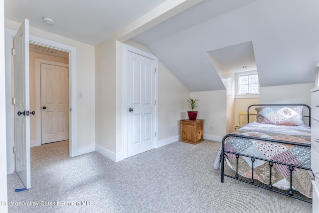 carpeted bedroom with vaulted ceiling and baseboards