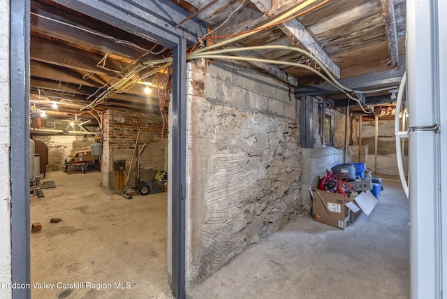 unfinished basement featuring freestanding refrigerator