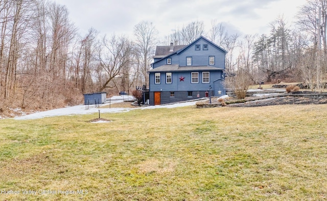 back of house with a lawn and a chimney