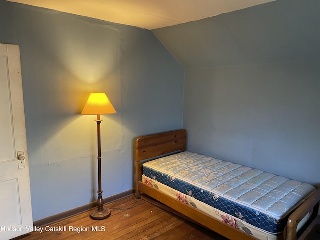 bedroom with hardwood / wood-style flooring and vaulted ceiling