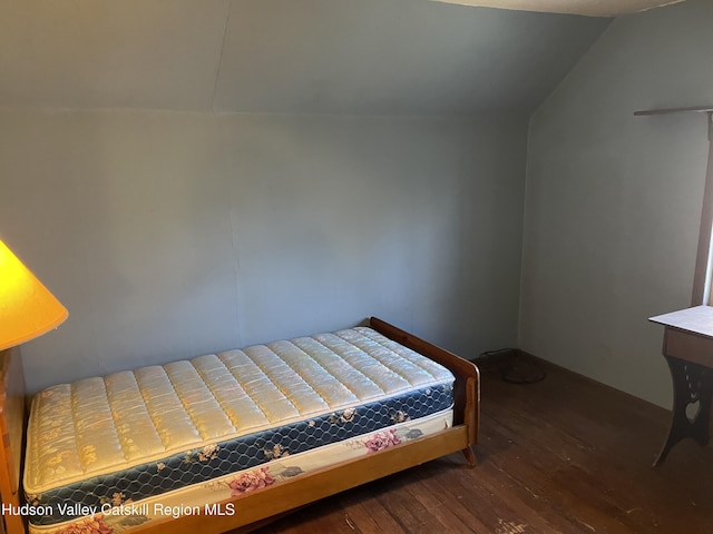 bedroom with dark wood-type flooring and lofted ceiling