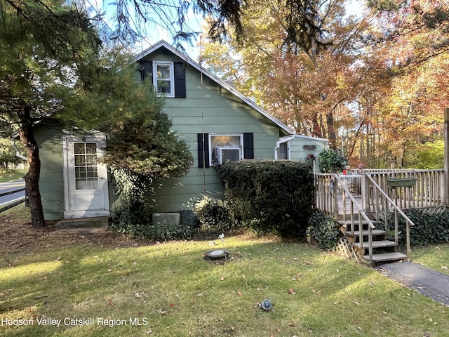 view of home's exterior featuring a wooden deck and a yard