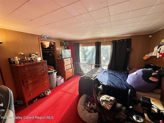 carpeted bedroom with wood walls