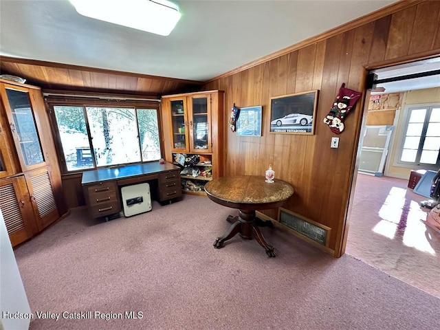 carpeted office featuring ornamental molding and wooden walls