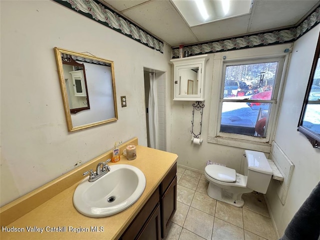 bathroom featuring tile patterned flooring, vanity, and toilet