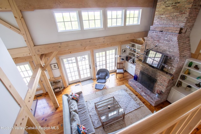 23 Raccoon Forks Rd, Old Chatham, NY 12136 - living room with healthy amount of natural light, a fireplace, light wood finished floors, and a high ceiling