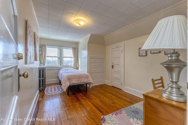 bedroom featuring ornamental molding and dark hardwood / wood-style flooring