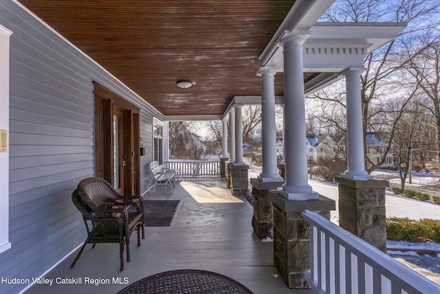 snow covered patio featuring a porch