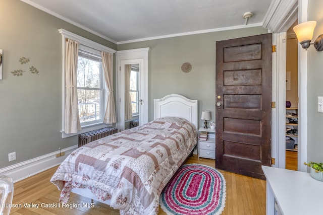 bedroom featuring radiator heating unit, ornamental molding, and light wood-type flooring