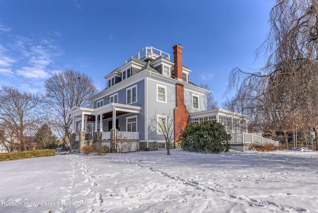 view of snow covered exterior featuring a sunroom and a porch