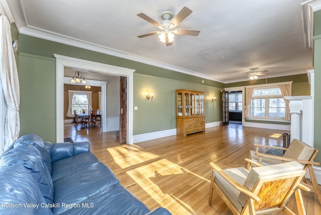 living room with crown molding, a healthy amount of sunlight, and wood-type flooring