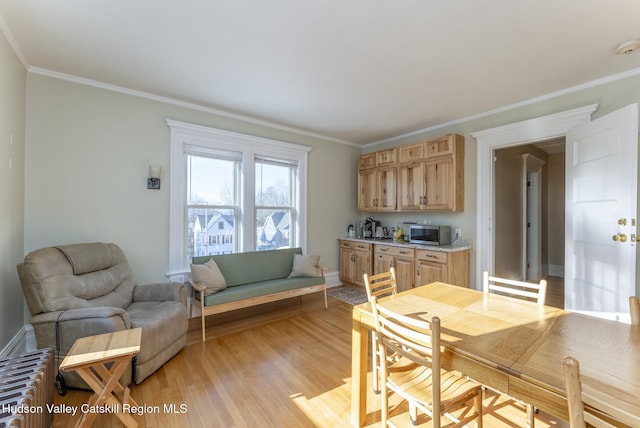 dining area featuring crown molding and light hardwood / wood-style flooring