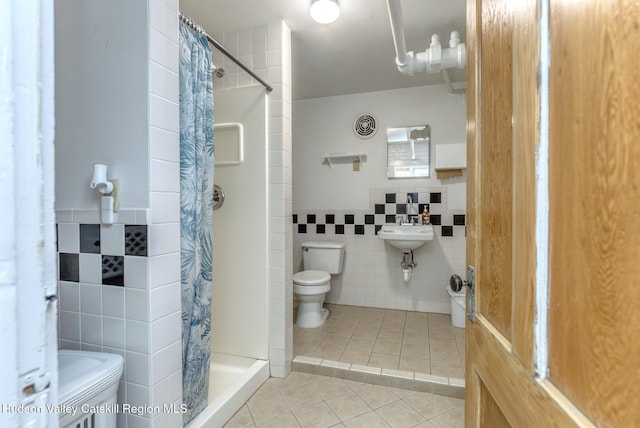 bathroom with sink, tile walls, toilet, tile patterned floors, and a shower with curtain