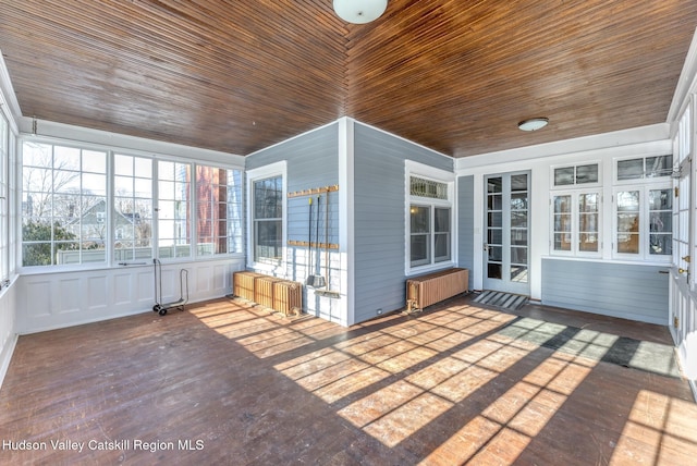 unfurnished sunroom with radiator heating unit and wooden ceiling