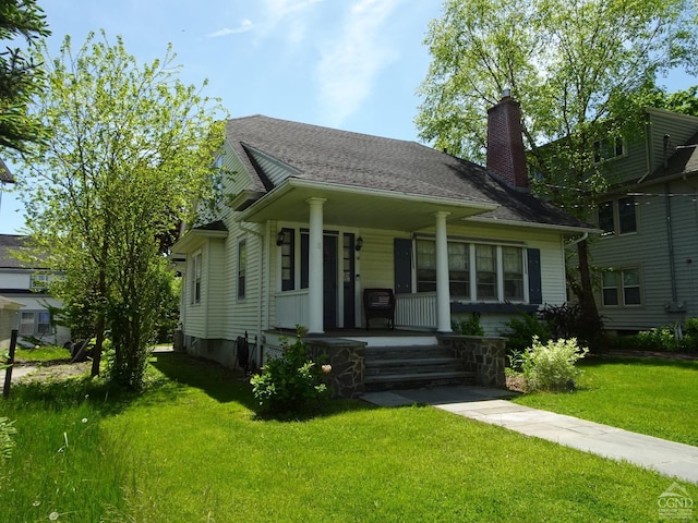 19 Aitken Ave, Hudson, NY 12534 - view of front of house featuring covered porch, a chimney, and a front yard