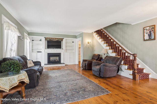 272 Main St, Middleburgh, NY 12122 - living area with stairs, crown molding, hardwood / wood-style floors, and a glass covered fireplace