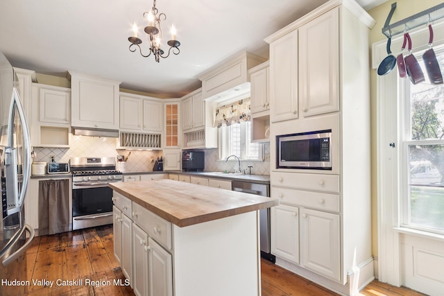 272 Main St, Middleburgh, NY 12122 - kitchen featuring appliances with stainless steel finishes, wooden counters, decorative backsplash, and dark wood-style floors
