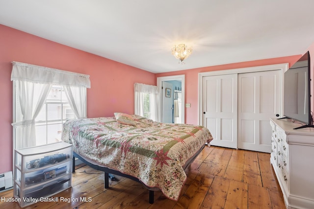 272 Main St, Middleburgh, NY 12122 - bedroom featuring multiple windows, a closet, light wood-type flooring, and a baseboard radiator