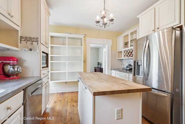272 Main St, Middleburgh, NY 12122 - kitchen with stainless steel appliances, wooden counters, open shelves, a chandelier, and decorative backsplash