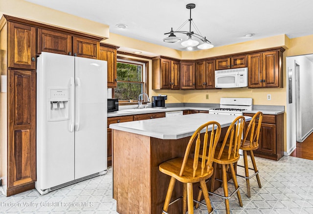 kitchen with a center island, sink, a notable chandelier, decorative light fixtures, and white appliances