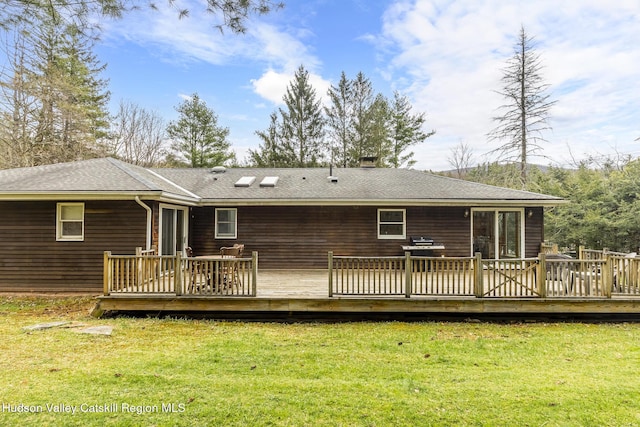 back of house featuring a deck and a lawn