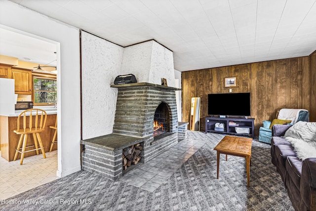 living room featuring a fireplace and wooden walls