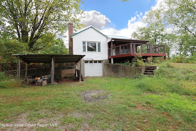 back of property with a carport, a deck, and a garage