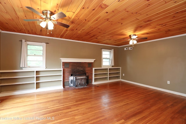 unfurnished living room featuring hardwood / wood-style flooring, plenty of natural light, wooden ceiling, and a wood stove