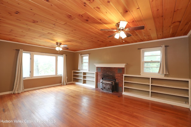 unfurnished living room featuring a wood stove, light hardwood / wood-style flooring, wooden ceiling, and plenty of natural light