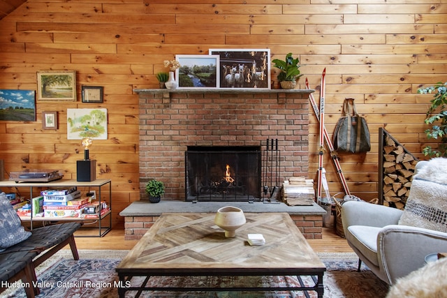 living room with a brick fireplace and wood finished floors