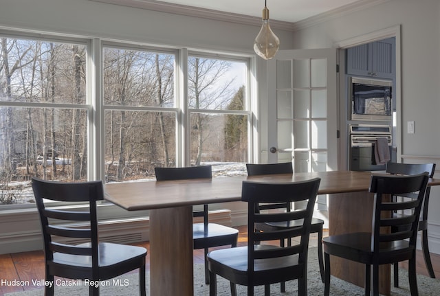 dining room with crown molding and wood finished floors