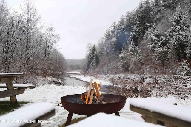 yard covered in snow featuring an outdoor fire pit