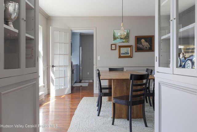 dining space featuring crown molding and wood finished floors