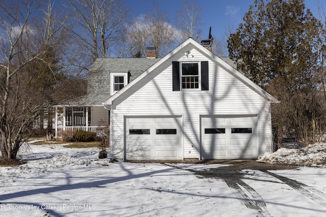 view of snow covered exterior with a shingled roof and a chimney