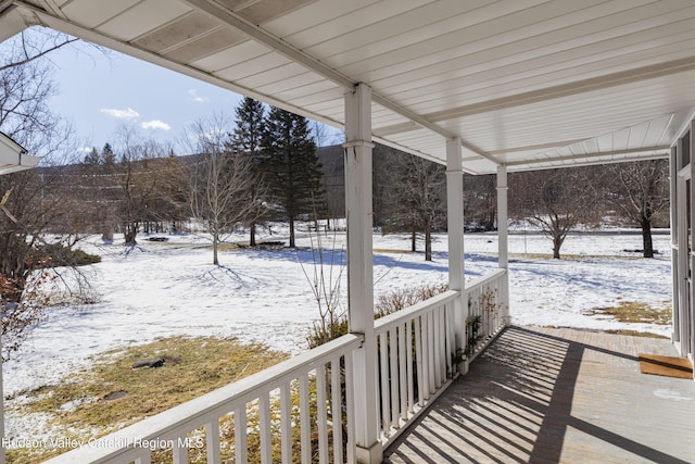 snow covered patio featuring covered porch