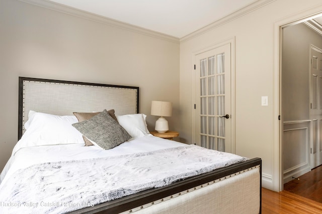 bedroom with wood finished floors and crown molding