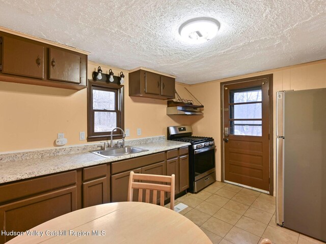 kitchen featuring plenty of natural light, stainless steel appliances, a textured ceiling, and sink