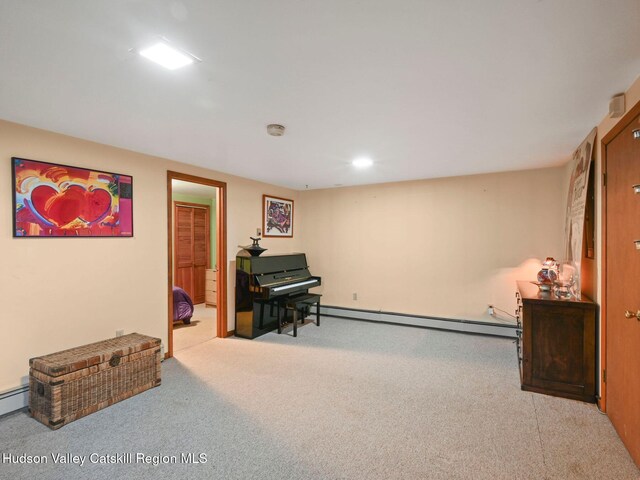 sitting room with light colored carpet and a baseboard heating unit