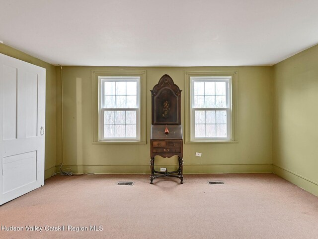 unfurnished room featuring plenty of natural light and light colored carpet