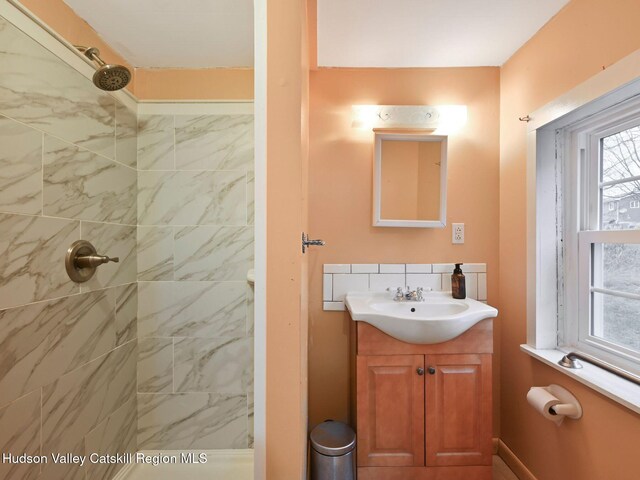 bathroom featuring a tile shower and vanity