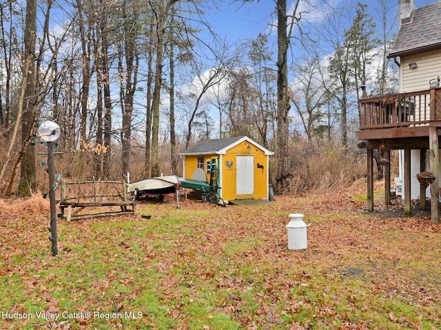 view of yard featuring a deck and a storage shed