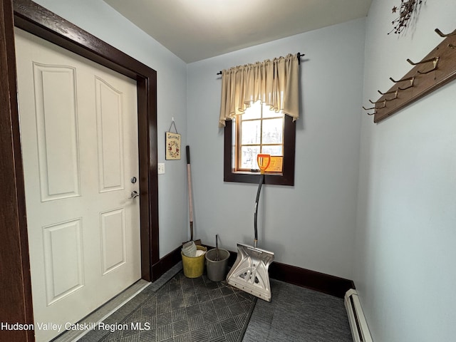 doorway to outside with baseboard heating and baseboards